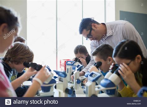 Students And Teacher At Microscopes Science Laboratory Classroom Stock