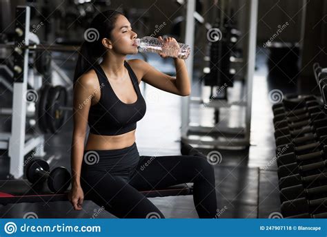 Fit Asian Woman Drink Water After Dumbbell Exercise In Fitness Gym