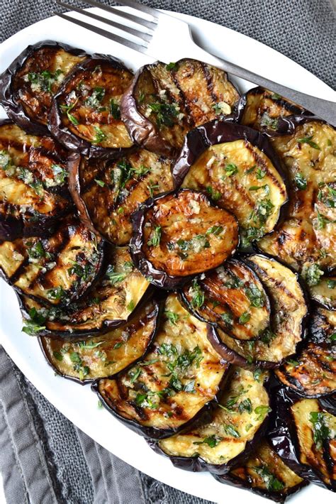 grilled eggplant and potatoes in a white dish with a fork on the side