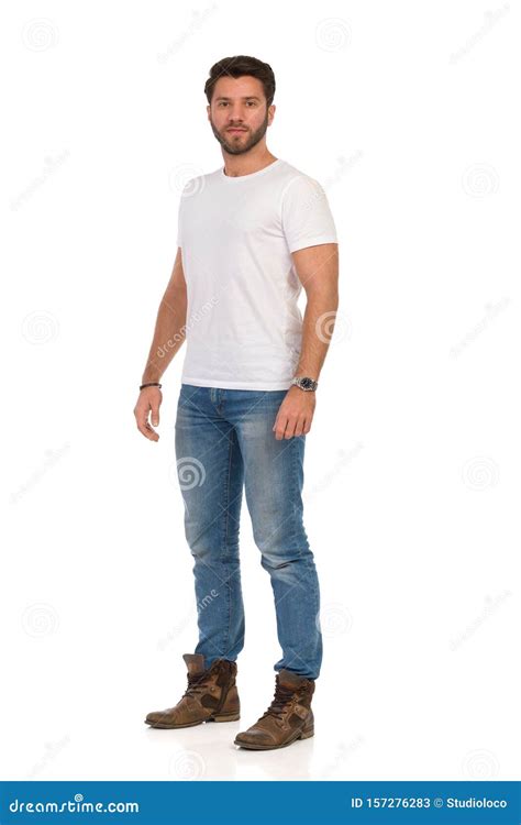 Serious Young Man In Jeans And White T Shirt Is Standing And Looking At