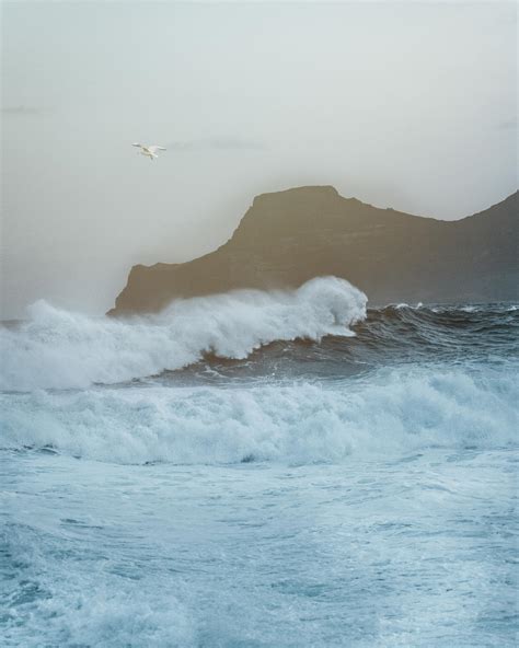 Stormy Sea Waving Near Rocky Cliff · Free Stock Photo