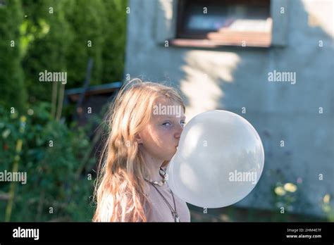 Cute Girl With Huge Chewing Gum Bubble In The Green Garden Stock Photo