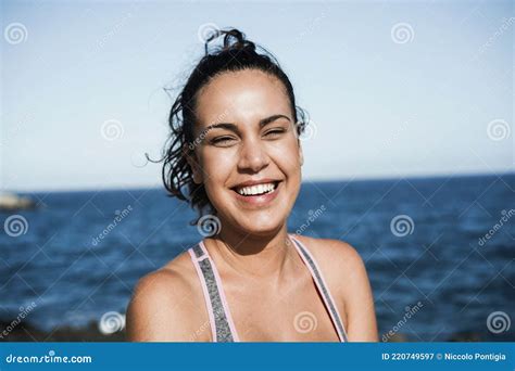 hispanic girl smiling on camera after sport session outdoor at the beach focus on face stock