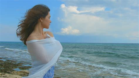 flirty mysterious woman standing alone on seashore enjoying beautiful sea view stock footage