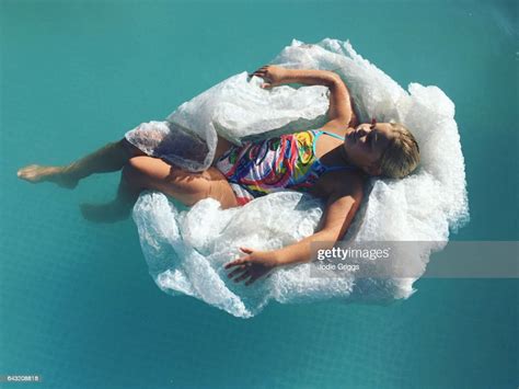 Child Using A Pile Of Discarded Bubble Wrap As An Inflatable Pool