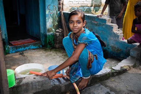 Brett Cole Photography A Girl Fills A Water Bucket In A Slum Area