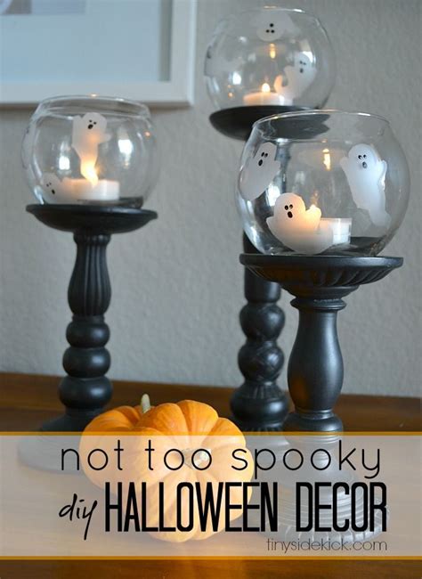 Two Glass Candles Are Sitting On Top Of A Table With Pumpkins In It And