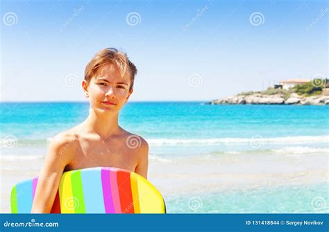 Adolescente Bello Con Il Bordo Di Nuotata Sulla Spiaggia Fotografia
