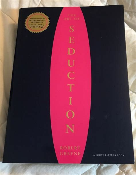 The Book Is Sitting On Top Of A White Bed Sheet And It Has A Pink Surfboard In Front Of It
