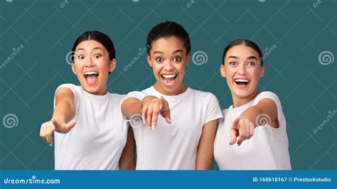 Three Excited Girls Pointing Fingers At Camera Over Turquoise Background Stock Image Image Of