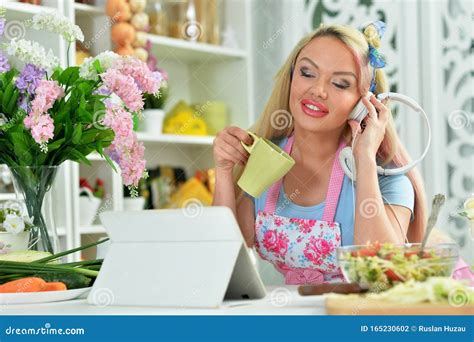 Portrait Of A Beautiful Young Woman Cooking In Kitchen Stock Photo