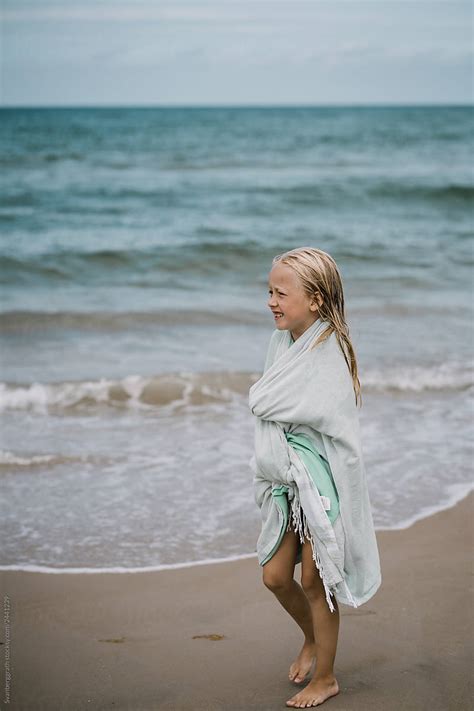 Blond Girl Walking The Beach With A Towel Around Her By Stocksy Contributor Svanberggrath