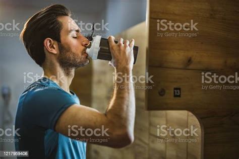 Profile View Of Athletic Man Drinking Water In A Gyms Locker Room Stock