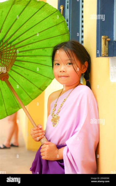 Portrait Of Girl Holding Umbrella While Standing Outdoors Stock Photo