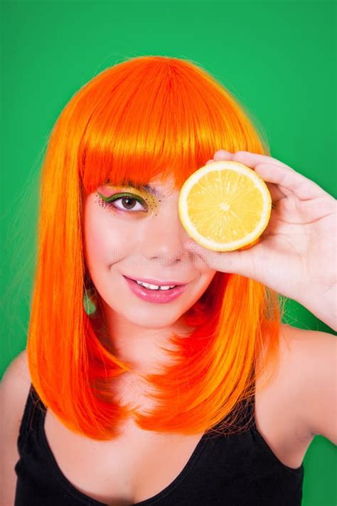 Portrait Of Red Haired Woman In Studio Close Up With Lemon Stock Photo
