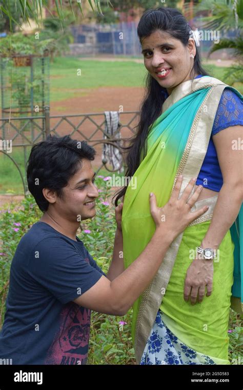 Young Indian Pregnant Woman With Her Husband Posing In A Park Mumbai