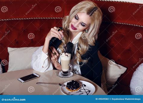 Gorgeous Woman With Blond Hair Sitting In Cafe With Coffee And Dessert