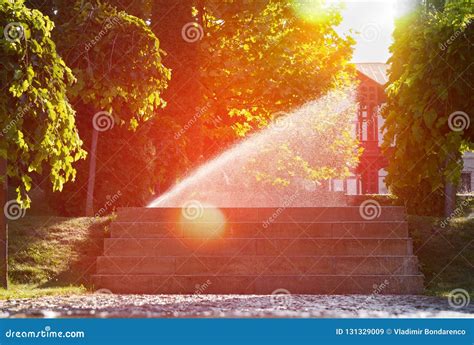Beautiful Landscape With Automatic Sprinkler Spraying Watering The Lawn