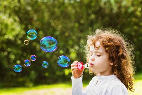 A Little Girl Blowing Soap Bubbles Closeup Portrait Beautiful C Stock