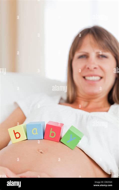 Good Looking Pregnant Woman Playing With Wooden Blocks While Lying On A