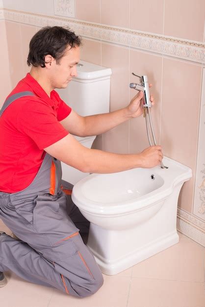 Premium Photo Male Plumber Repairing Toilet In The Apartment