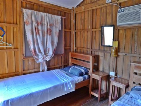 Two Beds In A Room With Wood Paneling