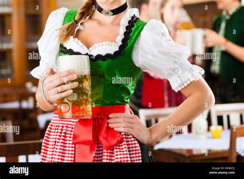 Young People In Traditional Bavarian Tracht In Restaurant Or Pub Stock