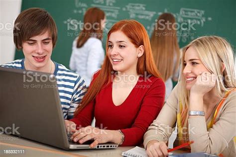 Group Of College Students Using Laptop In Classroom Stock Photo