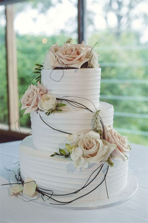 wedding cake 3 tier white icing peach and white flowers vine roses spring flowers elegant