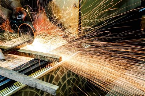 Worker Cutting Metal With Grinder Sparks While Grinding Iron Stock