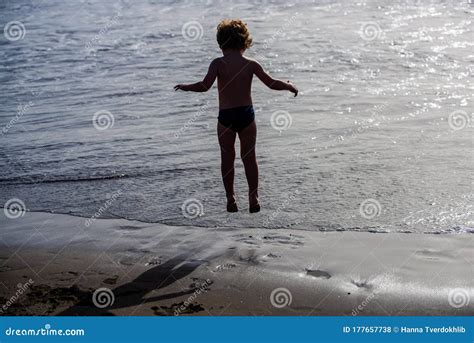 Jump Young Boy Enjoys The Cool Surf And Beaches Of Spain Or Us Happy