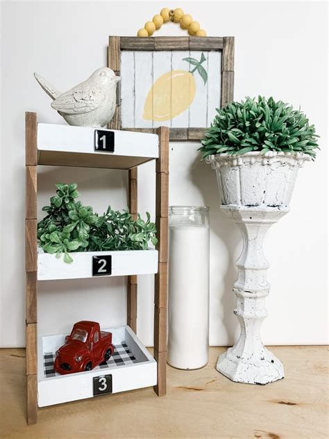 A Wooden Shelf With Plants On It Next To A Potted Plant And A White Vase
