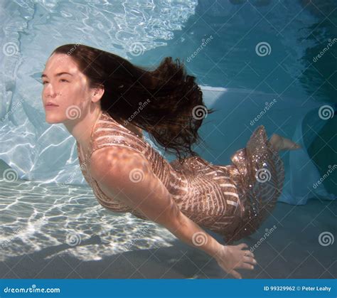 Woman Wearing A Gown Holding Her Breathe Underwater Stock Photo
