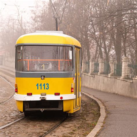 Yellow Tram Rides Through The Foggy City Alleypaving Stones Stock