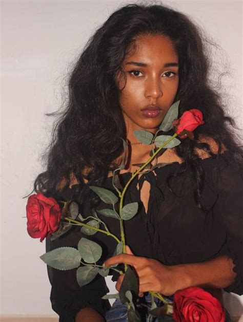 A Woman With Long Black Hair Holding Roses