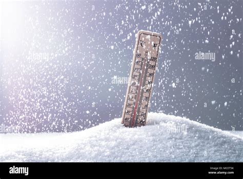 Thermometer On Snow Showing Low Temperature In Heavy Snowfall Stock