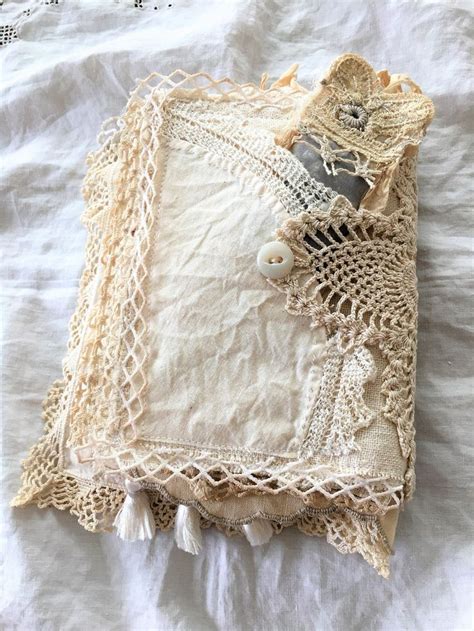An Old Lace Pillow Is Laying On A White Sheet With Crochet And Beads