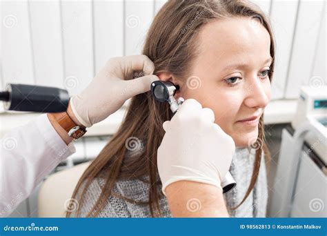 Ent Physician Looking Into Patient`s Ear With An Instrument Private