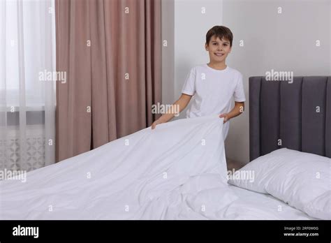 Boy Changing Bed Linens In Bedroom Domestic Chores Stock Photo Alamy