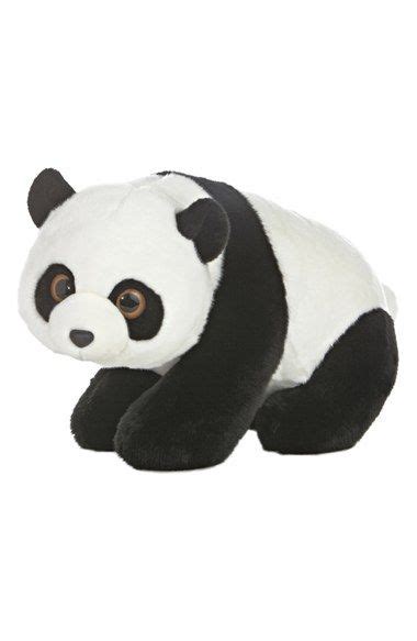 A Stuffed Panda Bear Sitting On Top Of A White Floor Next To A Black