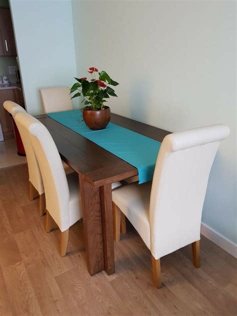 It's made from solid wood, with a circular surface set on four flared, tapered legs. Extendable walnut solid wood dining table with 4 leather ...