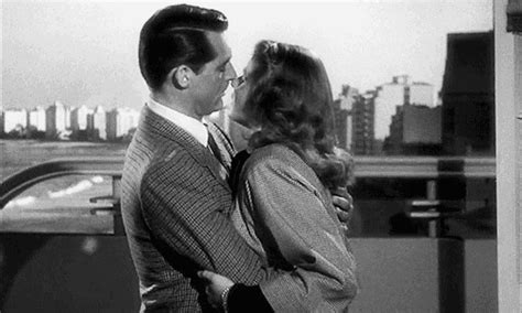 Black And White Photograph Of A Man Kissing A Woman On The Roof Of A