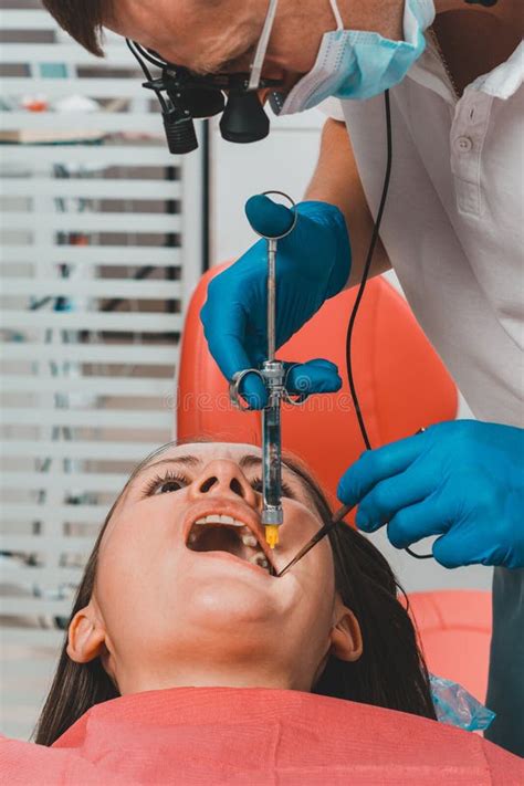 El Dentista Con La Ayuda De Una Jeringa De Carpule Autoinyecta