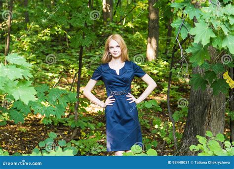 Beautiful Woman In Elegant Dress And Charming Smile Posing In The Park