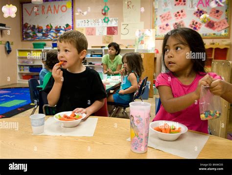 Hispanic Pre Kindergarten Age Children Eat Snacks At Pre School Girl