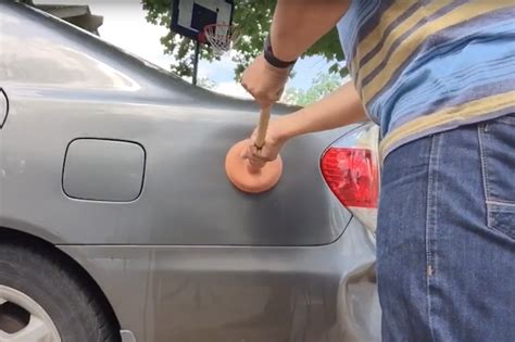 Watch As A Man Demonstrates How To Remove Dents From A Car Yourself