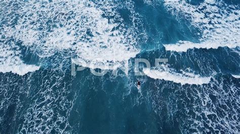Aerial Top Down View Of Surfer With Surf Board In Ocean Wave From