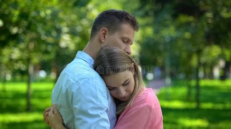 Man Hugging And Comforting Upset Girlfriend In Park Togetherness And