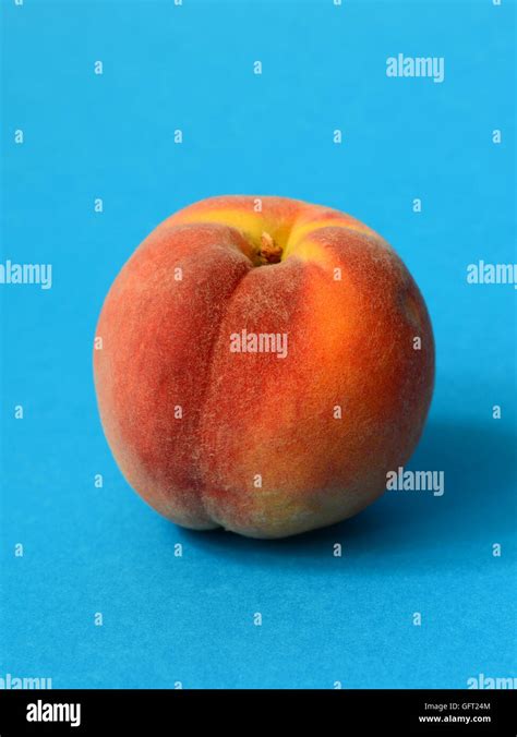 One Ripe Peach On A Blue Background Stock Photo Alamy