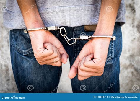close up hands tied up handcuffs in behind his body arrested man handcuffed hands at the back